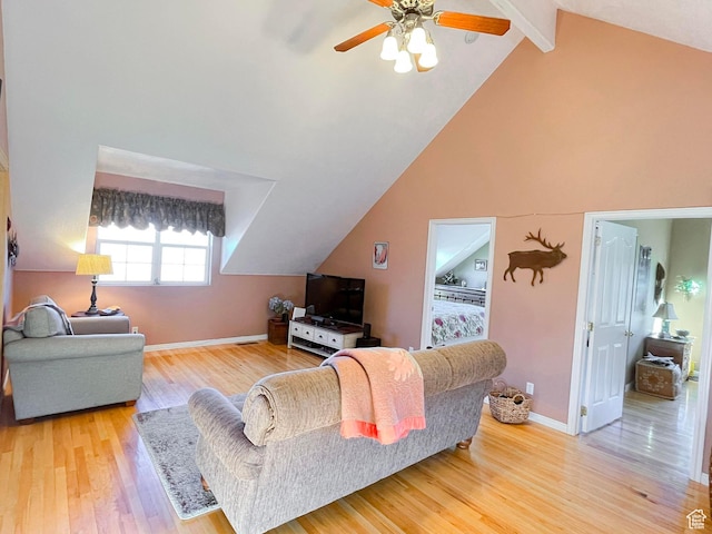 living room with ceiling fan, high vaulted ceiling, wood finished floors, baseboards, and beamed ceiling