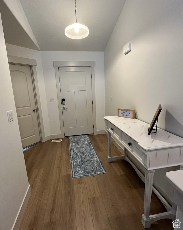 foyer entrance featuring vaulted ceiling, wood finished floors, and baseboards