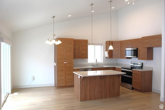 kitchen featuring appliances with stainless steel finishes, a sink, high vaulted ceiling, light countertops, and a center island