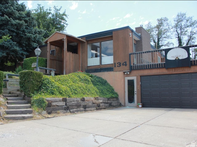 view of front of home featuring a garage, driveway, and a chimney