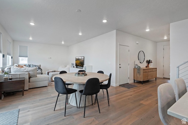 dining area featuring light wood-style floors, recessed lighting, stairway, and baseboards