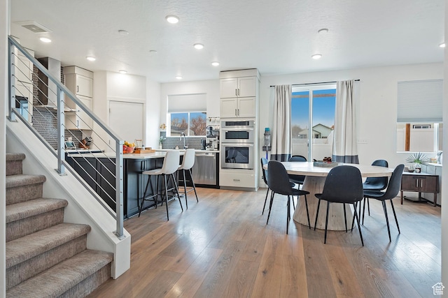 dining room with stairs, light wood-type flooring, and recessed lighting