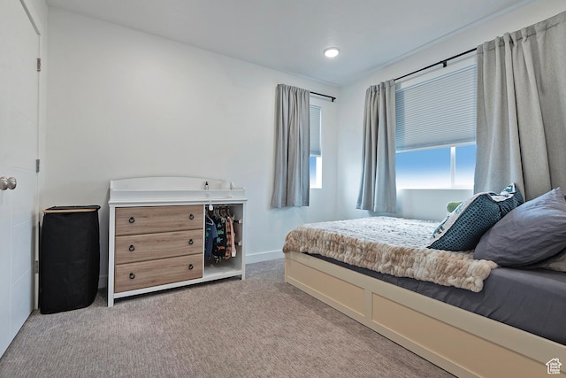 bedroom featuring baseboards and light colored carpet