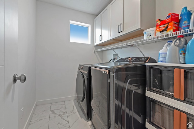 clothes washing area featuring washing machine and dryer, marble finish floor, and baseboards