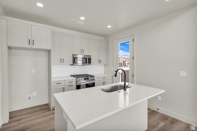 560 W Aqua Cv Unit 506, St George, UT 84790 - kitchen featuring light wood finished floors, tasteful backsplash, visible vents, appliances with stainless steel finishes, and a sink