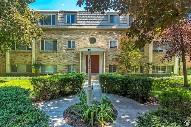 view of front of property with mansard roof and brick siding