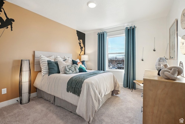 bedroom featuring baseboards and light carpet