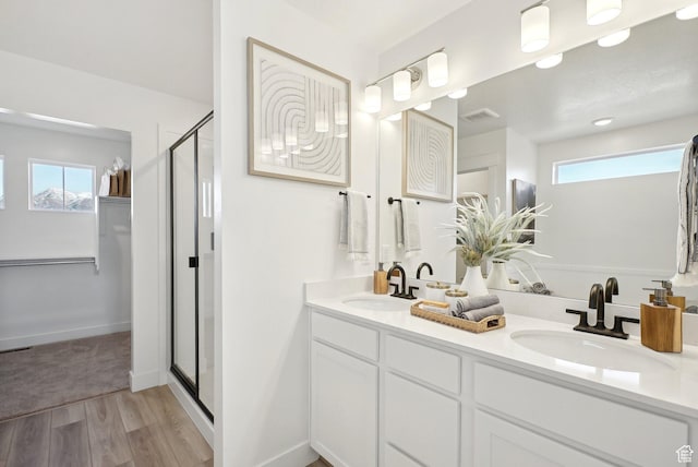 bathroom featuring a stall shower, visible vents, a sink, and wood finished floors