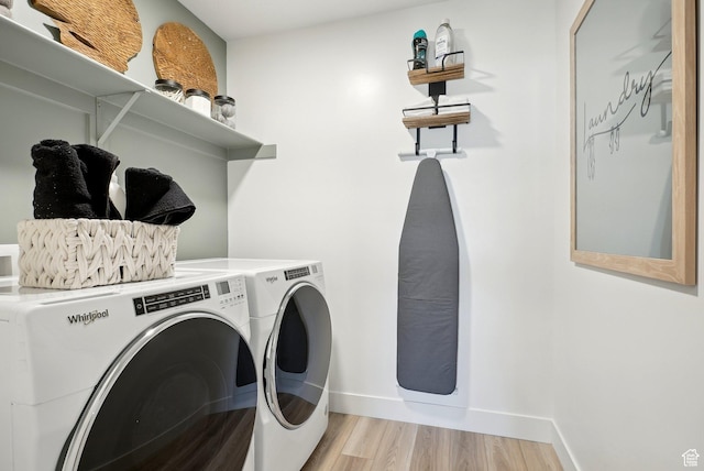 laundry room with laundry area, light wood-style floors, baseboards, and washing machine and clothes dryer