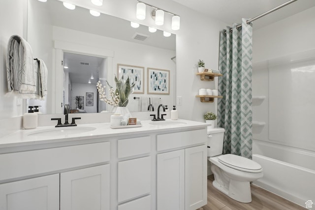 full bathroom with double vanity, a sink, wood finished floors, and toilet