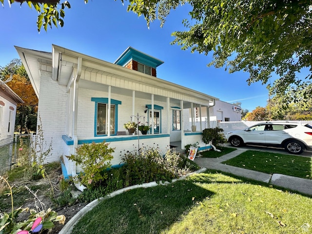 516 S Freedom Blvd, Provo, UT 84601 - view of front of home with a porch, brick siding, fence, and a front lawn