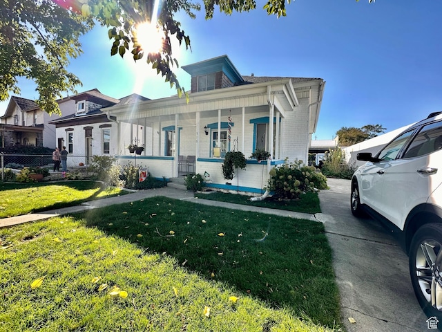 516 S Freedom Blvd, Provo, UT 84601 - bungalow-style home featuring covered porch, brick siding, fence, and a front lawn