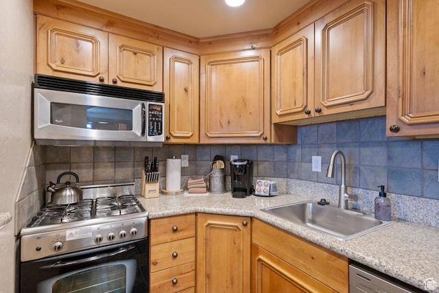 kitchen featuring decorative backsplash, appliances with stainless steel finishes, light countertops, and a sink