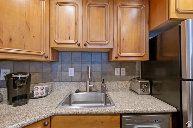 kitchen with decorative backsplash, light countertops, appliances with stainless steel finishes, and a sink