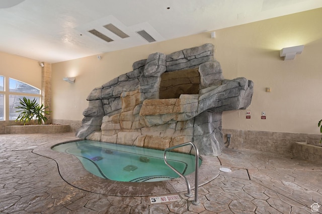 view of swimming pool featuring an indoor hot tub