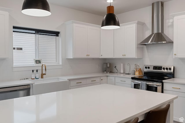 628 S 1080 E, Smithfield, UT 84335 - kitchen with appliances with stainless steel finishes, wall chimney exhaust hood, decorative backsplash, light countertops, and white cabinetry