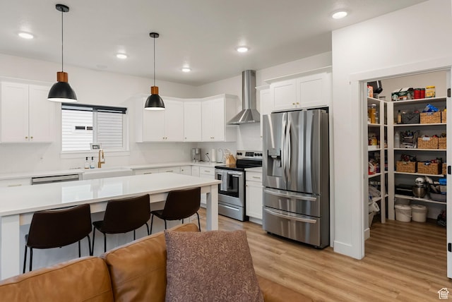 628 S 1080 E, Smithfield, UT 84335 - kitchen with appliances with stainless steel finishes, wall chimney range hood, a sink, a kitchen bar, and light countertops