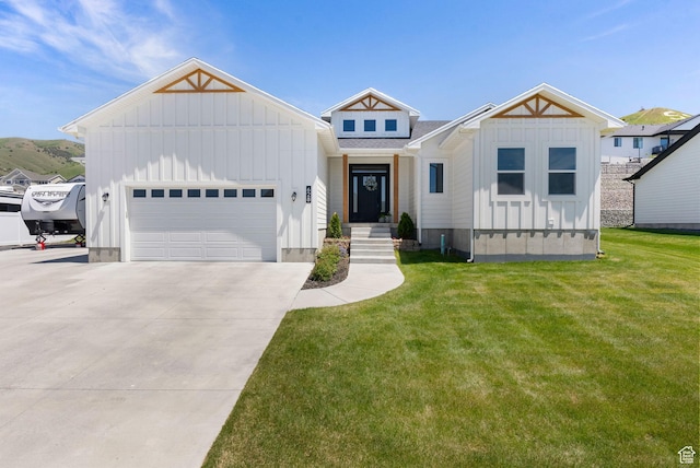 628 S 1080 E, Smithfield, UT 84335 - view of front of house featuring board and batten siding, a front lawn, driveway, and a garage