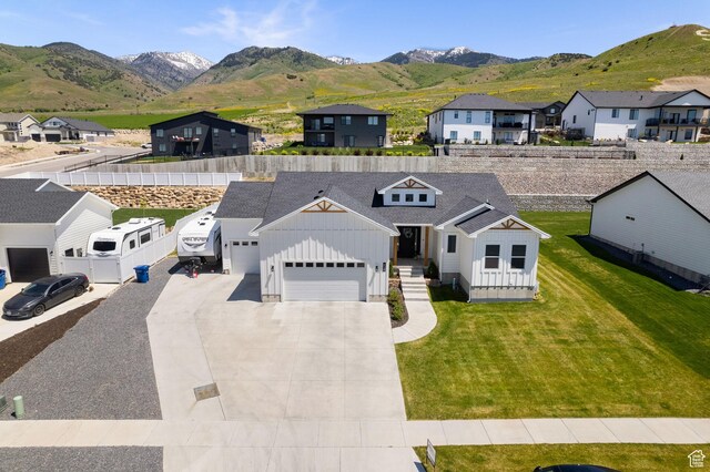 628 S 1080 E, Smithfield, UT 84335 - view of front of home featuring board and batten siding, an attached garage, a residential view, a mountain view, and concrete driveway