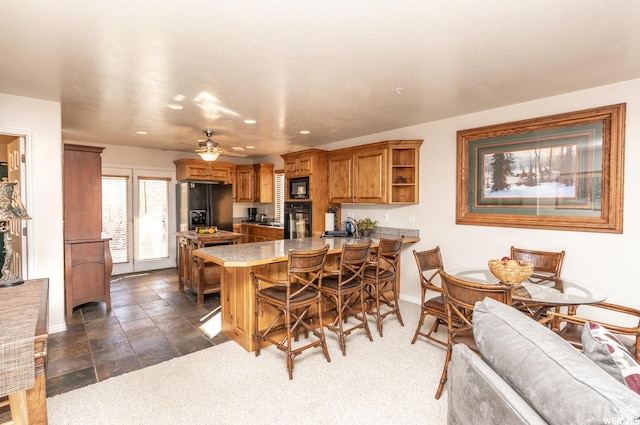 3612 N Huntsman Path Unit 603, Eden, UT 84310 - kitchen with brown cabinets, a breakfast bar area, open shelves, a peninsula, and black appliances