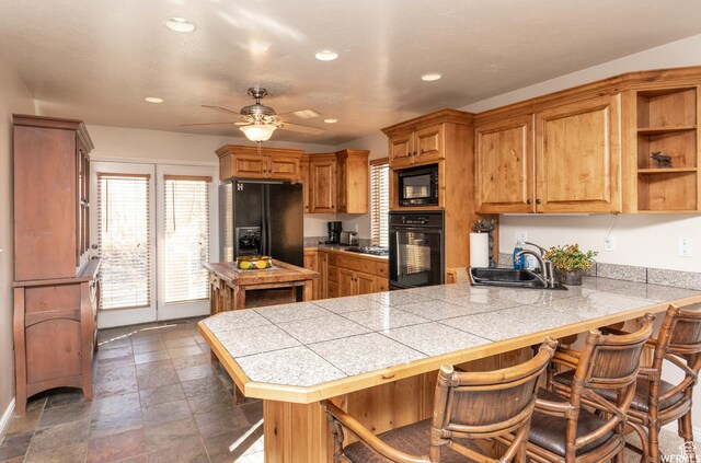 3612 N Huntsman Path Unit 603, Eden, UT 84310 - kitchen featuring a kitchen breakfast bar, a sink, a peninsula, and black appliances