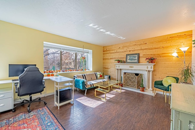 home office with a fireplace, wooden walls, a textured ceiling, and wood finished floors