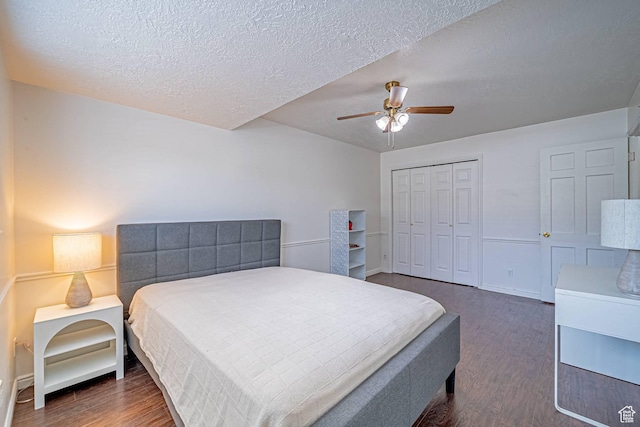 bedroom featuring a textured ceiling, a closet, a ceiling fan, and dark wood-type flooring