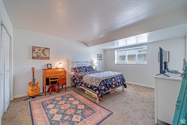 carpeted bedroom with a textured ceiling and baseboards