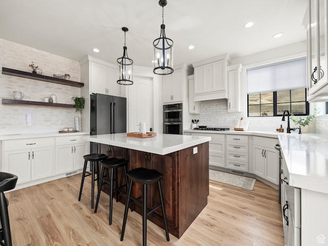 5351 S Lincoln Beach Rd, Spanish Fork, UT 84660 - kitchen featuring a breakfast bar area, a sink, a kitchen island, gas stovetop, and freestanding refrigerator