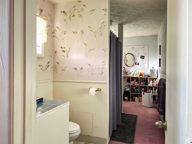 bathroom featuring toilet and a textured ceiling