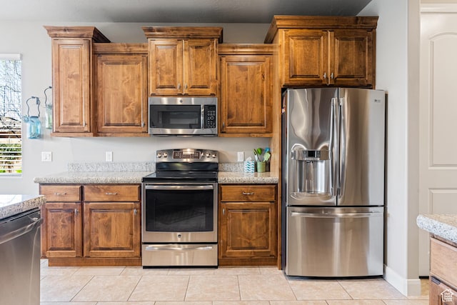 1921 W 390 N Street N, St. George, UT 84770 - kitchen featuring appliances with stainless steel finishes, brown cabinetry, a wealth of natural light, and light stone countertops