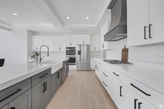 219 W Elinor Ln, Washington, UT 84780 - kitchen featuring custom exhaust hood, stainless steel appliances, light countertops, light wood-style floors, and a sink