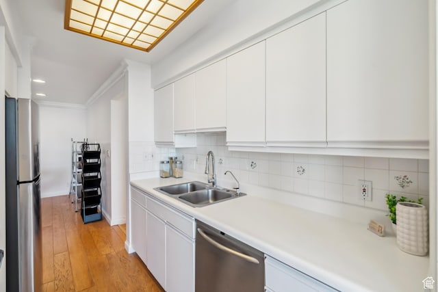 777 E S Temple S Unit 4A, Salt Lake City, UT 84102 - kitchen with stainless steel appliances, light countertops, white cabinetry, decorative backsplash, and light wood-type flooring