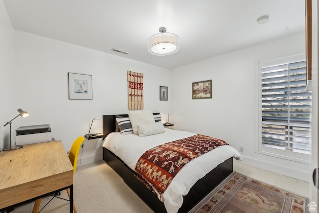 bedroom featuring baseboards, visible vents, and carpet flooring