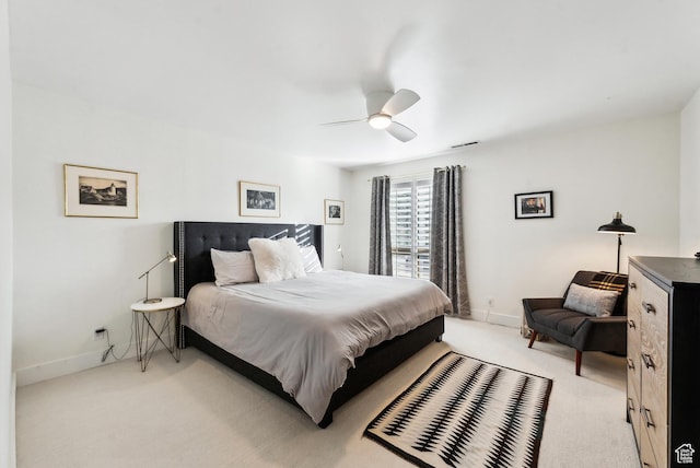 bedroom with light carpet, ceiling fan, visible vents, and baseboards