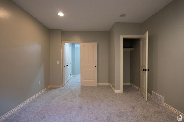 unfurnished bedroom with carpet floors, a closet, visible vents, and baseboards
