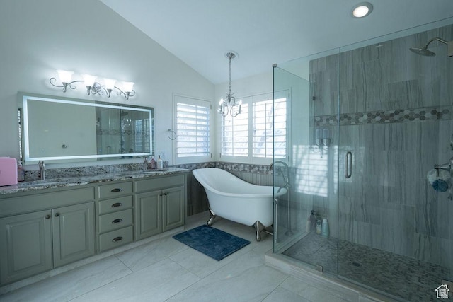 bathroom featuring lofted ceiling, a stall shower, a freestanding tub, and a sink