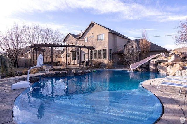 outdoor pool with a patio area, a pergola, and a water slide