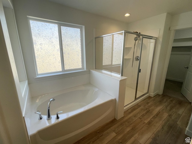 8416 N Sun Crest Dr, Eagle Mountain, UT 84005 - full bath featuring a stall shower, wood finished floors, a walk in closet, a bath, and recessed lighting