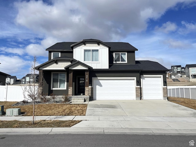 view of front of home with concrete driveway, fence, and an attached garage