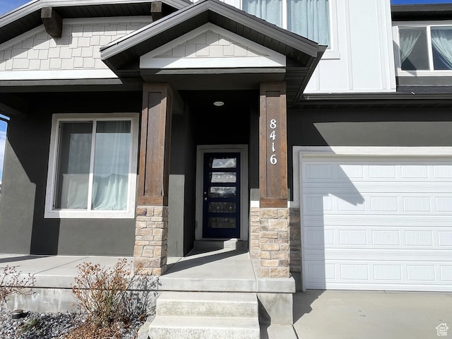 8416 N Sun Crest Dr, Eagle Mountain, UT 84005 - entrance to property featuring a garage, stone siding, and stucco siding