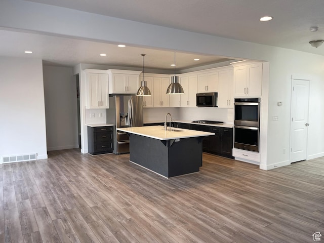 8416 N Sun Crest Dr, Eagle Mountain, UT 84005 - kitchen featuring stainless steel appliances, light countertops, visible vents, and wood finished floors