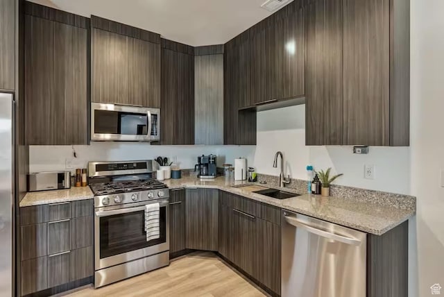 840 W Hilltop Ct, Francis, UT 84036 - kitchen with modern cabinets, light stone countertops, stainless steel appliances, light wood-style floors, and a sink