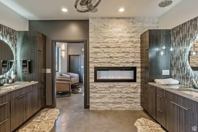 840 W Hilltop Ct, Francis, UT 84036 - full bathroom with two vanities, finished concrete floors, a fireplace, a sink, and recessed lighting