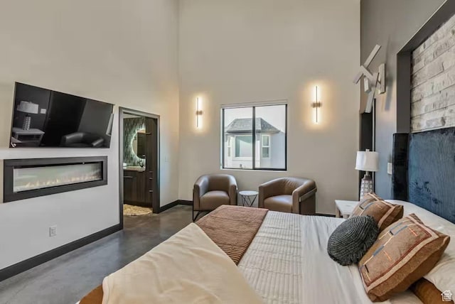 840 W Hilltop Ct, Francis, UT 84036 - bedroom with concrete floors, a glass covered fireplace, a towering ceiling, and baseboards