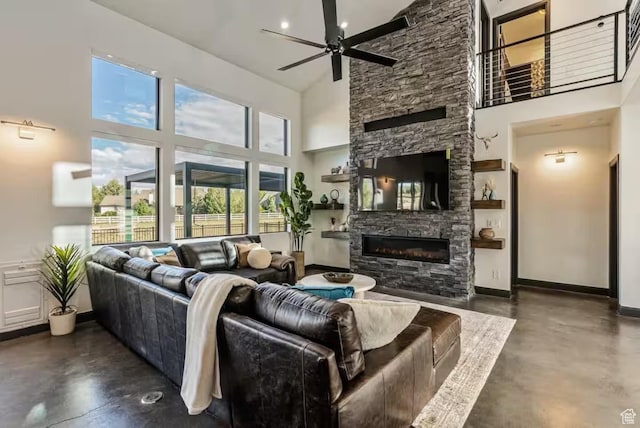 840 W Hilltop Ct, Francis, UT 84036 - living room with baseboards, a ceiling fan, a towering ceiling, concrete flooring, and a stone fireplace