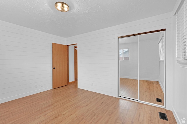 8693 S Vaquero Dr, Sandy, UT 84094 - unfurnished bedroom featuring wood finished floors, visible vents, a closet, and a textured ceiling