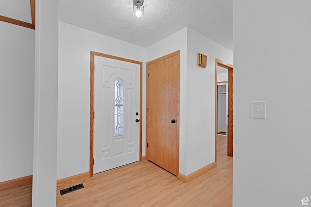 8693 S Vaquero Dr, Sandy, UT 84094 - foyer featuring visible vents, baseboards, a textured ceiling, and light wood finished floors