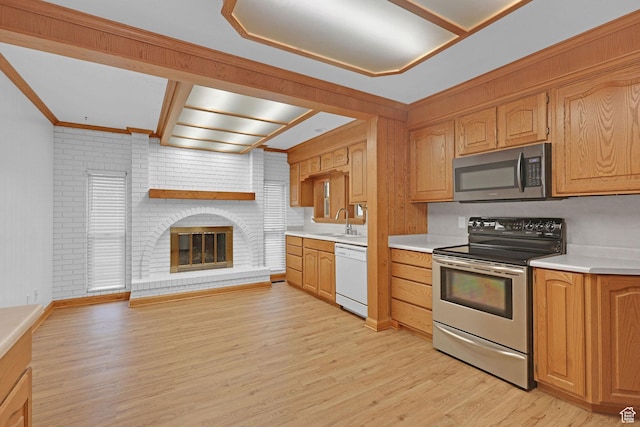 8693 S Vaquero Dr, Sandy, UT 84094 - kitchen featuring light wood-style flooring, a sink, stainless steel appliances, light countertops, and a brick fireplace