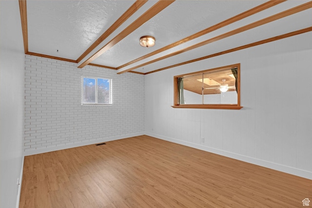 8693 S Vaquero Dr, Sandy, UT 84094 - unfurnished room with wood finished floors, visible vents, brick wall, a textured ceiling, and beamed ceiling